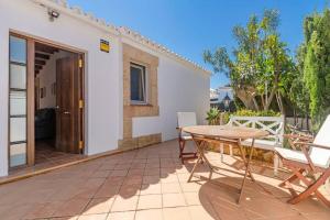 a patio with a wooden table and chairs at Villa Mica in Son Carrio