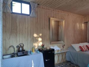 a kitchen with a sink and a bed in a room at Cabaña vista al volcán en centro de Pucón in Pucón