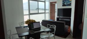 sala de estar con mesa y ordenador portátil. en Puerto Santa Ana Suites Guayaquil en Guayaquil