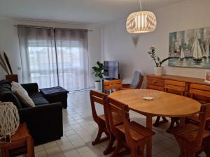 een woonkamer met een tafel en een bank bij Velamar Praia 411 - 300m da praia in Albufeira