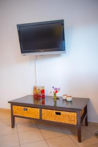 a coffee table with a flat screen tv on a wall at Byron’s Home in Stalida