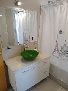 a bathroom with a green sink and a shower curtain at Buenaventura Apartment in Mendoza