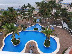 an overhead view of a resort swimming pool with palm trees at Carabelas de Colon con balcon grande y vista hermosa in Playas
