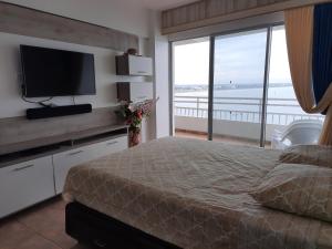 a bedroom with a bed with a television and a balcony at Carabelas de Colon con balcon grande y vista hermosa in Playas +28 photos