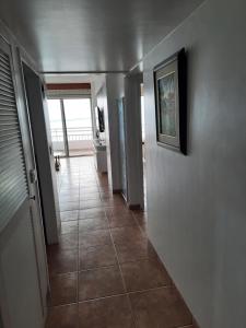 a hallway with a tile floor and a wall with a picture at Carabelas de Colon con balcon grande y vista hermosa in Playas
