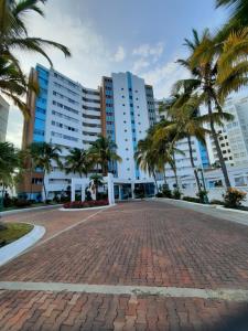 a brick road with palm trees in front of buildings at Carabelas de Colon con balcon grande y vista hermosa in Playas