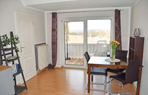 a living room with a table and chairs and a window at Ferienwohnung mit Balkon am Mönchgraben in Baabe +15 photos