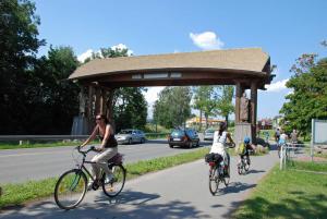 two women riding bikes down a road at Ferienwohnung mit Balkon am Mönchgraben in Baabe