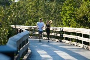 a man and a woman walking across a bridge at Naples Grande Beach Resort in Naples