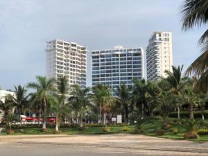 un groupe de grands bâtiments avec des palmiers devant dans l'établissement Punta Centinela Apartment, à Punta Blanca