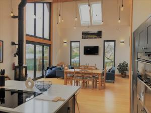 an open kitchen and living room with a dining room at Cranmer - New Eco Beach House 4 Bed HOT TUB & Bikes in Camber