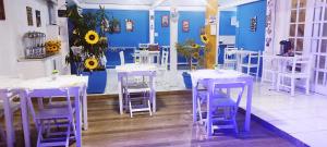 Pokój z niebiesko-białymi stołami i krzesłami w obiekcie Pousada Gente Bonita Centro w mieście Búzios