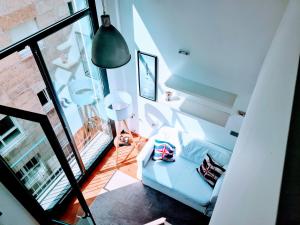 een woonkamer met een witte bank en een groot raam bij El Camarote del Fraga Apartamento en pleno centro de Vigo con parking in Vigo