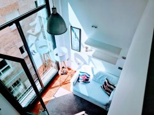 a living room with a white couch and a large window at El Camarote del Fraga Apartamento en pleno centro de Vigo con parking in Vigo