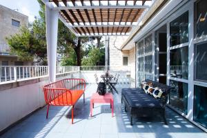 - une terrasse avec 2 chaises et un banc dans un bâtiment dans l'établissement Shlomo Molkho Luxury Apartment By Nimizz, à Jérusalem