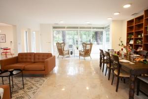 - un salon avec un canapé, une table et des chaises dans l'établissement Shlomo Molkho Luxury Apartment By Nimizz, à Jérusalem