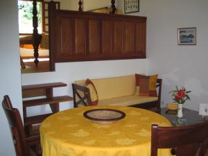een eetkamer met een gele tafel en stoelen bij Les Cycas in Saint-Claude