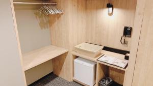 a small kitchen with a refrigerator and a phone at First Cabin Midosuji Namba in Osaka