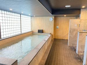 a swimming pool in a building with a large window at First Cabin Midosuji Namba in Osaka