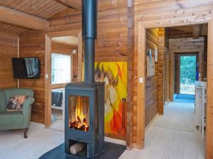 a fireplace in a log cabin with a living room at Holiday home Kolind VI in Kolind