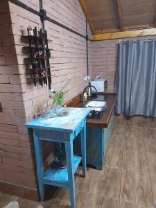 a blue table in a room next to a brick wall at Sossego do Interior III in Nova Petrópolis +10 photos