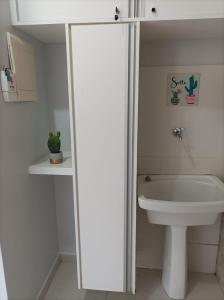 a white bathroom with a toilet and a sink at ALDEIA do LAGO Caldas Novas Lindo Apt com Cozinha Mobília Nova Pode Levar Bebidas na Área das Piscinas in Caldas Novas