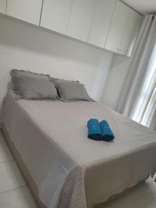 a pair of blue shoes sitting on a bed at Muro Alto condomínio CLUBE AP 411 in Porto De Galinhas