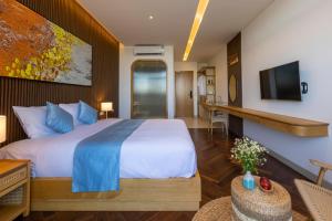 a bedroom with a large bed and a living room at The Stay Saigon Riverfront in Gò Công