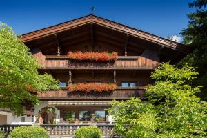 a house with flower boxes on the front of it at Pension Mühlbachhof in Alpbach