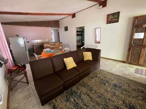 een woonkamer met een bruine bank en een tafel bij Casa turtle Bogue in Tortuguero