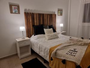 a bedroom with a bed with a wooden headboard at Marfil in Posadas