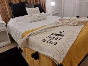 a bed with a comforter with a sign on it at Marfil in Posadas