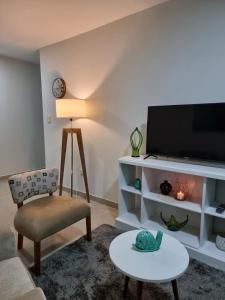 a living room with a tv and a chair and a table at Marfil in Posadas