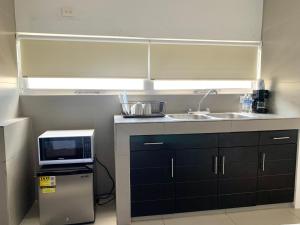 a small kitchen with a sink and a microwave at Océano Studios in Cancún