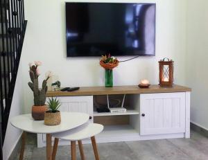 a tv on a wall with a table and a table sidx sidx sidx at Casa Sant Vicent 63 in Teulada