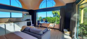 a kitchen and living room with a couch and a table at The Quarters Ocean-View Chalet in Gisborne