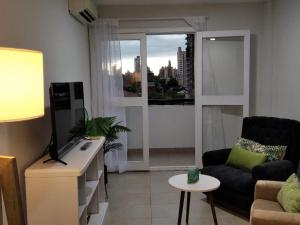 a living room with a couch and a tv and a window at Marfil in Posadas