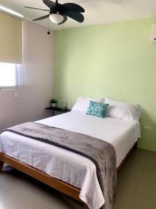 a bedroom with a large bed with a ceiling fan at Océano Studios in Cancún