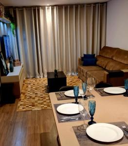 a living room with a table with plates and wine glasses at Gramado Loft in Gramado