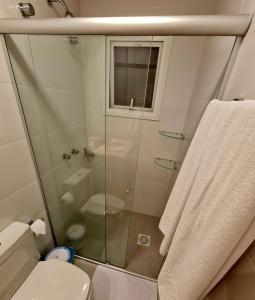 a bathroom with a toilet and a glass shower at Gramado Loft in Gramado