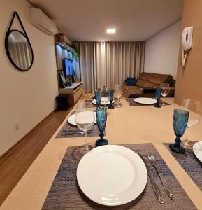 a living room with a table with plates and wine glasses at Gramado Loft in Gramado +13 photos