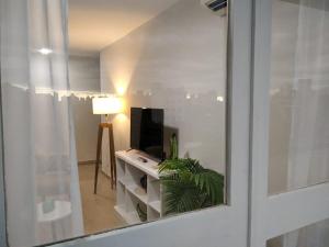 a living room with a tv and a window at Marfil in Posadas