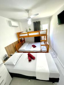 two bunk beds in a room with red shoes on them at Arraial do Cabo - Condomínio com cara de Resort in Arraial do Cabo