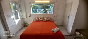 een slaapkamer met een groot oranje bed en 2 ramen bij Green Serene Abode in Meerut