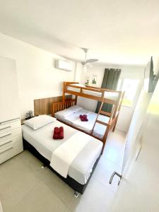 a bedroom with two bunk beds with red pillows at Arraial do Cabo - Condomínio com cara de Resort in Arraial do Cabo