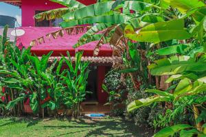 a red bench in front of a house with plants at Casas e apartamentos da Ilda in Trancoso