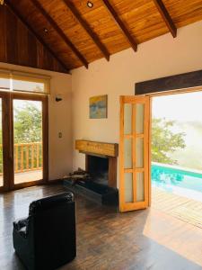 a living room with a fireplace and a pool at AYAR- Portentos & Cabañas QORIANKA in Virú