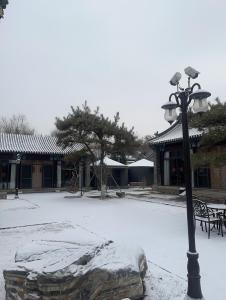 un pôle lumineux avec de la neige à côté d'un bâtiment dans l'établissement Chengde Kai Ren Hua Fu Jiu Dian (Bi Shu Shan Zhuang Dian), à Chengde