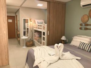a bedroom with two bunk beds with white towels at Flat aconchegante no Eco Resort Praia dos Carneiros - Cama Queen in Praia dos Carneiros +54 photos