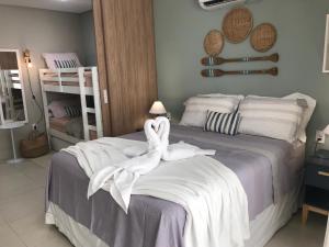 a bedroom with a bed with white towels on it at Flat aconchegante no Eco Resort Praia dos Carneiros - Cama Queen in Tamandaré